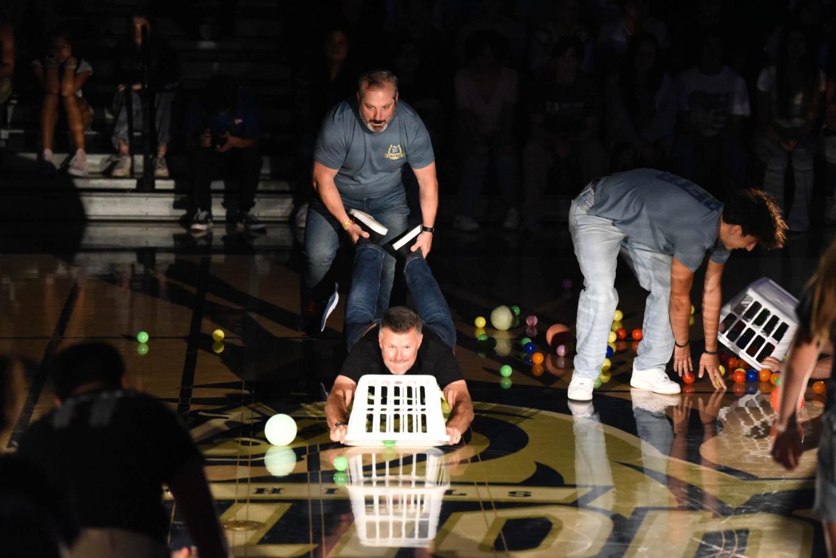 Putting on their game face, Spanish teacher Alvaro Serrano and AP Euro teacher Robert Lynde work together as they compete in a game of “Hungry Hippo.” Shortly after, the crowd cheered as this teacher duo won the game. 
