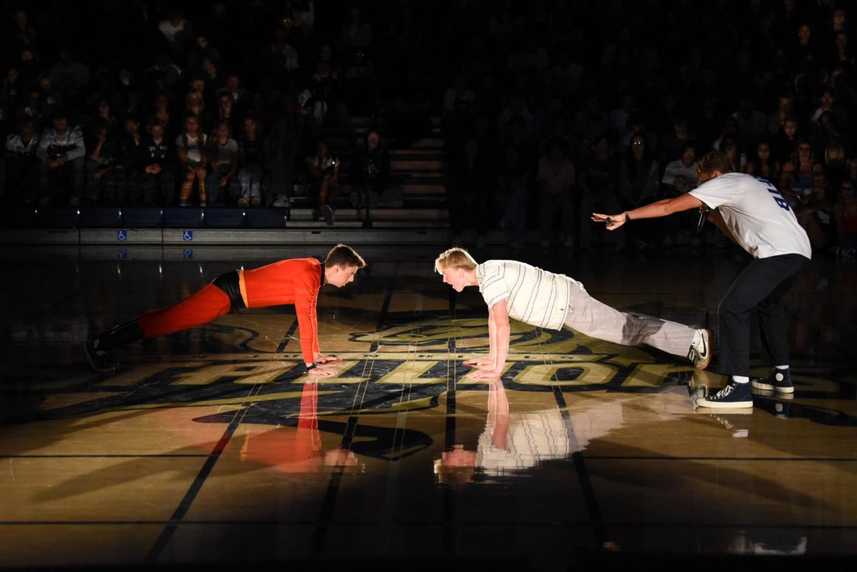 For his final performance of the pep rally, Zack Smith (12) challenges Nathan Zollinger (12) to a push-up competition. After challenging Zollinger, Smith abruptly ended the competition in a comedic manner.