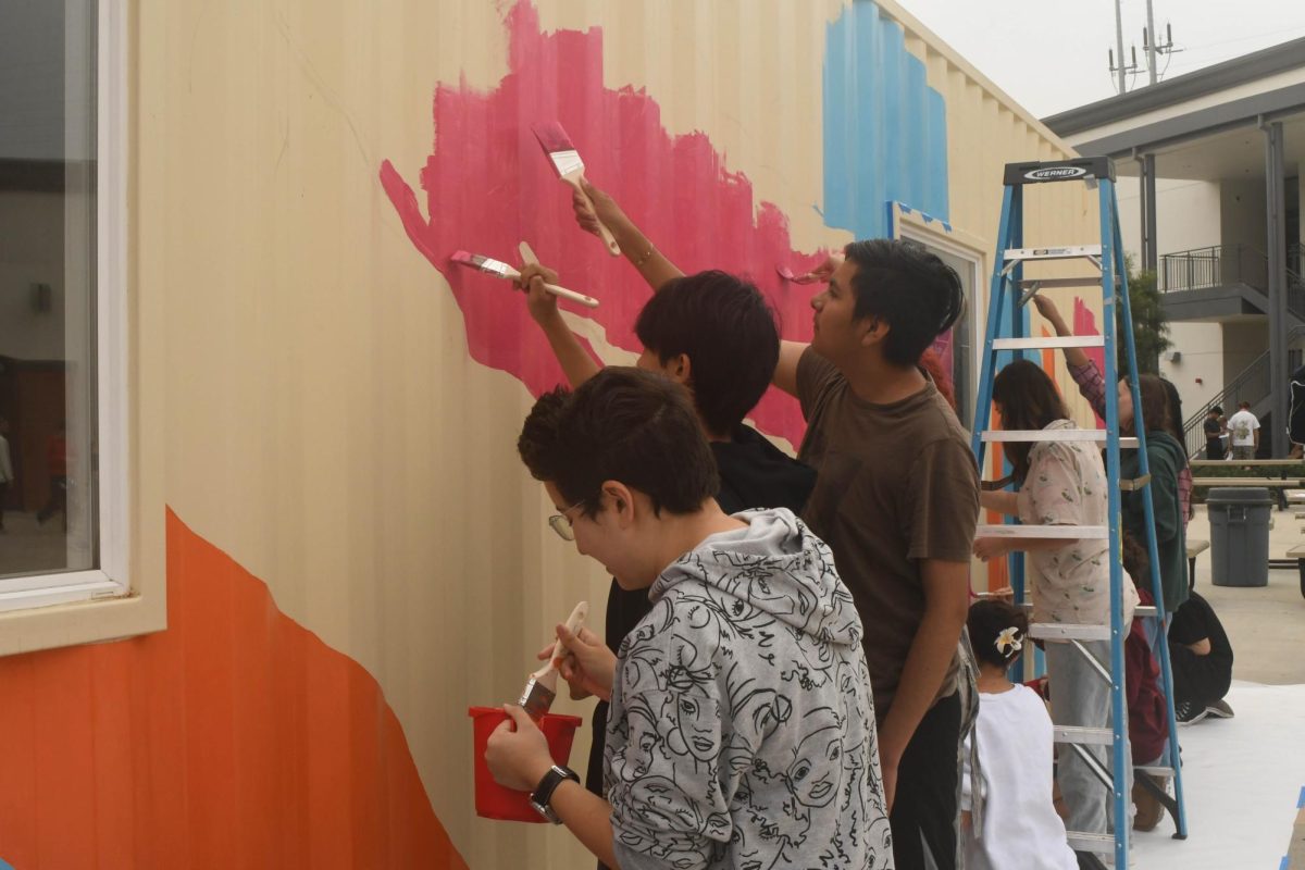 Painting the VAPA Art Gallery, Kylie Pringle (12), Tyler Vo (10), and Fernando Campos (12) help prepare the container for the unveiling. Mrs. Arman’s AP students had the opportunity to design and paint the gallery that will showcase student art pieces from all art classes around campus. The gallery is planned to have its grand opening within the next month as students work on polishing the gallery for display. 