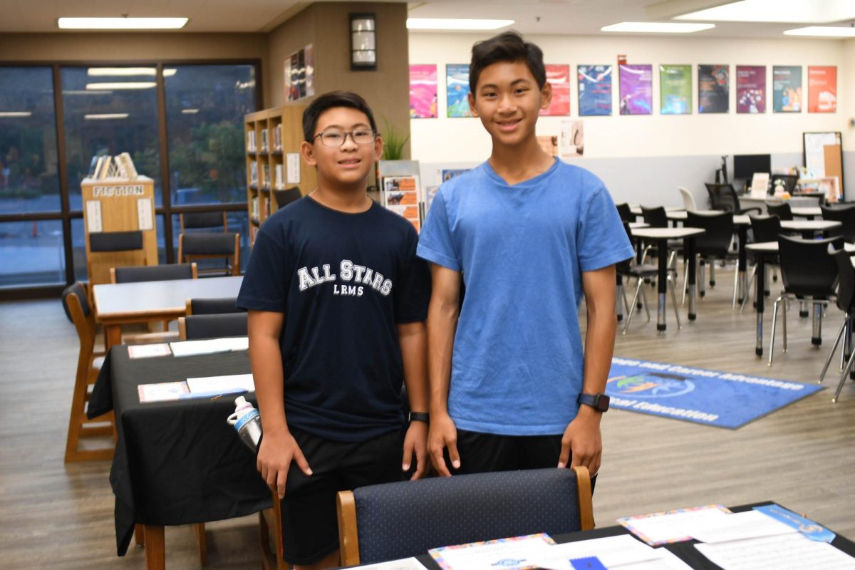 Artists are given the opportunity to embrace imperfection at the Reflections Gallery in the library. Composer, Bradon Velasco shows off his award winning artwork, with his brother. Photo by Cadence Henss.