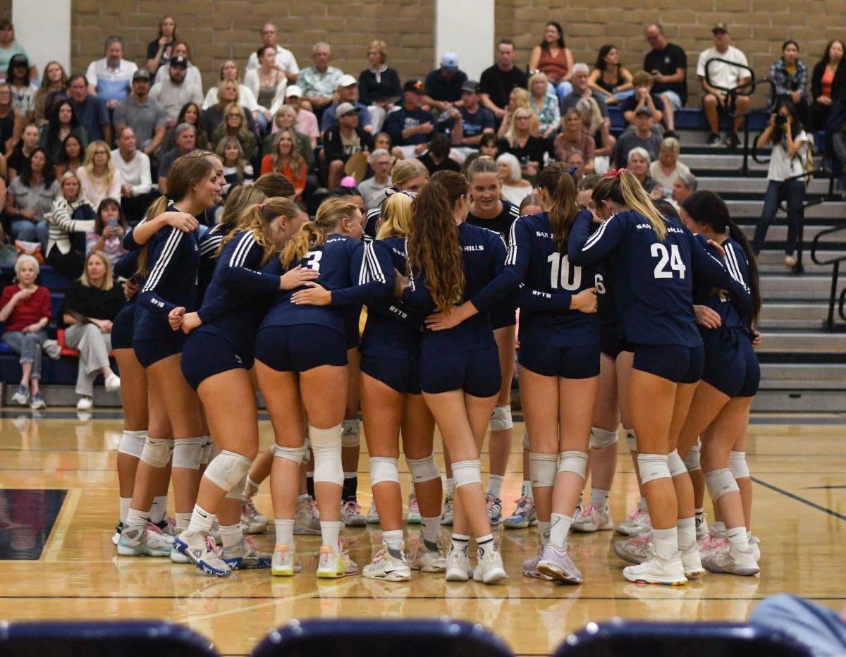 Huddled together before the final game of the season, the girls varsity volleyball team prepares to face Trabuco Hills High School. In celebration of senior night, the seniors were honored for their athletic achievements before the game.