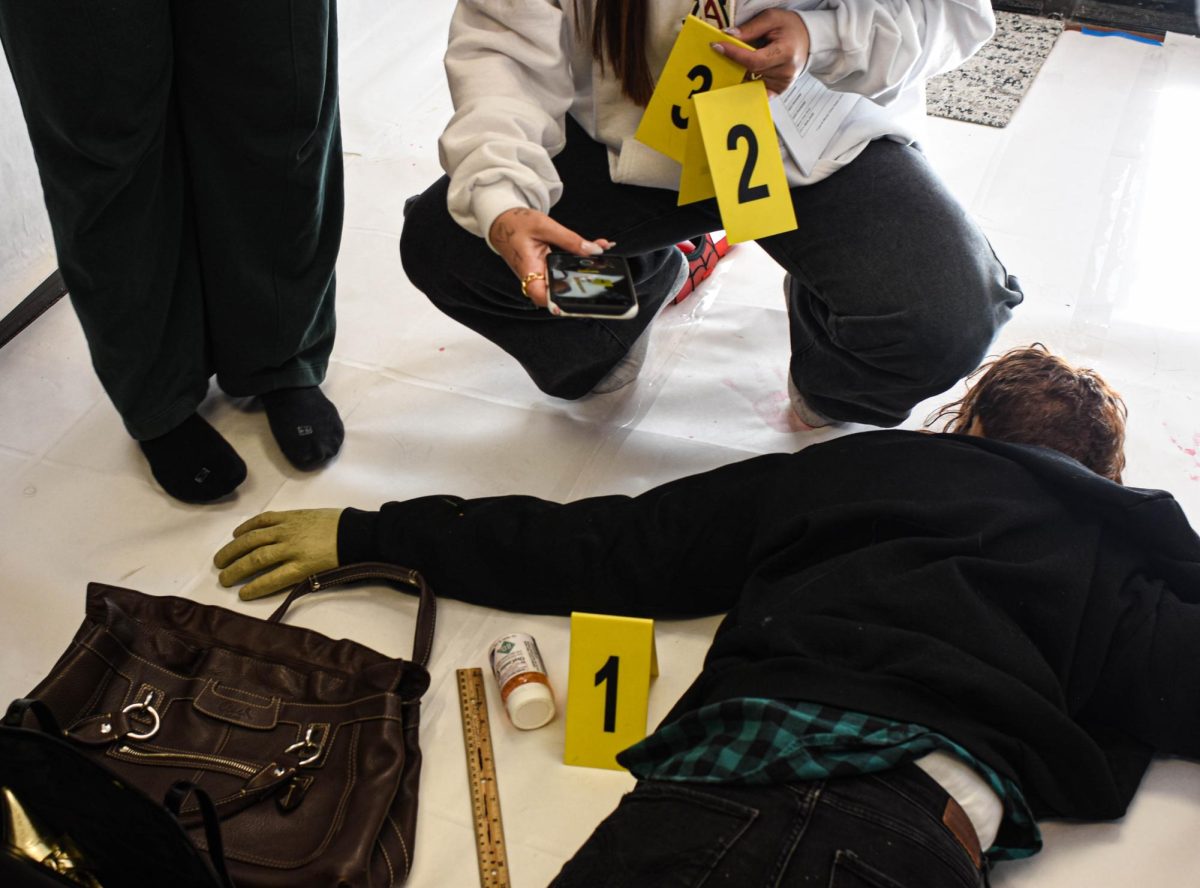 As Forensic students begin their next crime scene, they examine and document valuable evidence around the room. They are currently learning about the different kinds of blood spatter and where they came from to piece together and solve what events occurred during the crime.