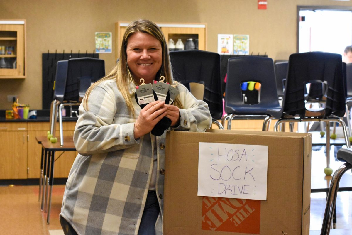 National Honors Society Advisor Crystal Stevenson collects new socks for the HOSA Sock Drive. HOSA is a club on campus and a national student organization for future healthcare leaders. They collaborated with NHS to donate socks to the Orange County Rescue Mission homeless shelter. Students brought new neutral toned socks from Wednesday to Friday, and earned one hour of service for each pack of socks.