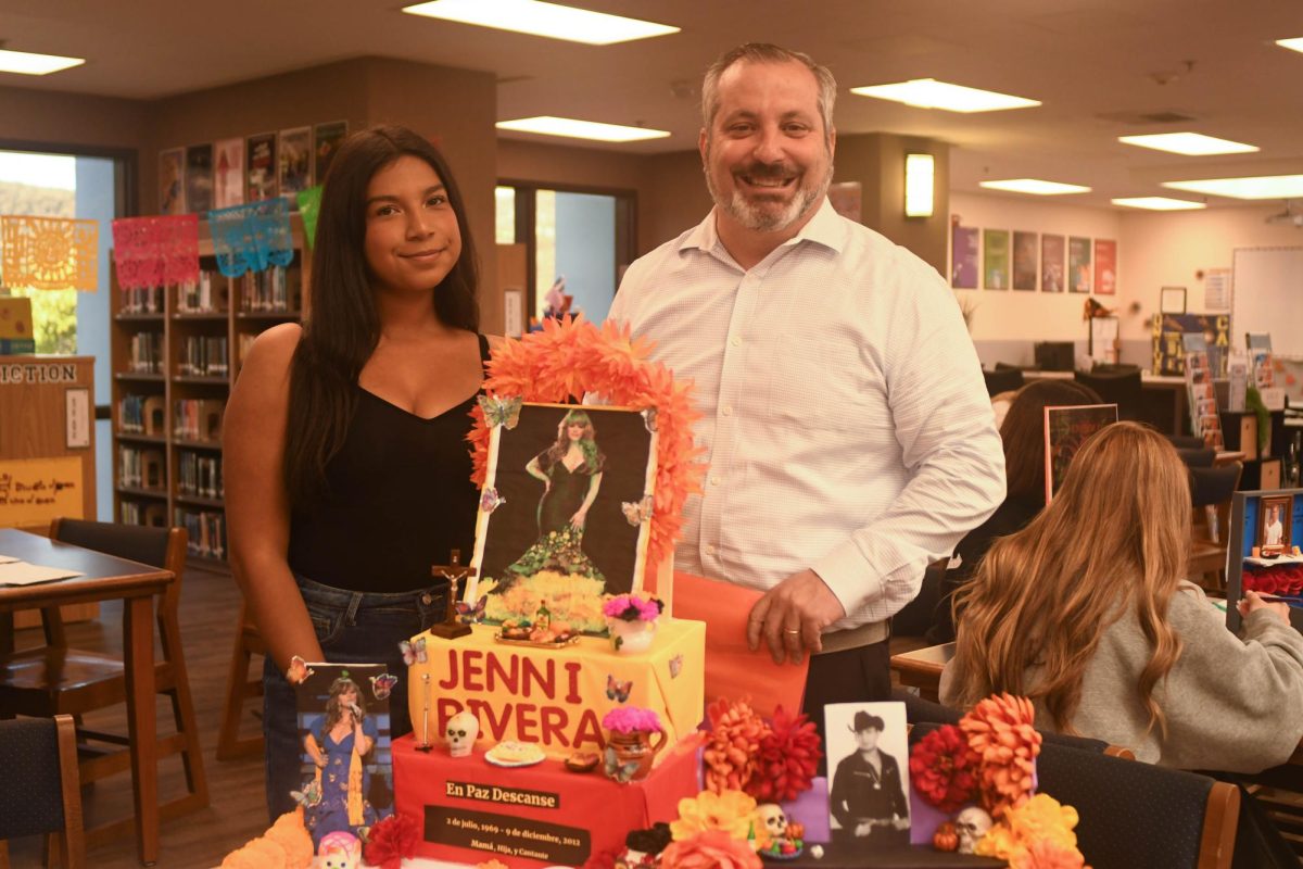 Proudly posing in front of an altar celebrating Hispanic-American icon Jenni Rivera, Diana Vega (10) and Spanish teacher Alvaro Serrano show off their espíritu. In honor of Dia de los Muertos, the Spanish for Spanish Speakers II class made altars celebrating various icons who passed away. 