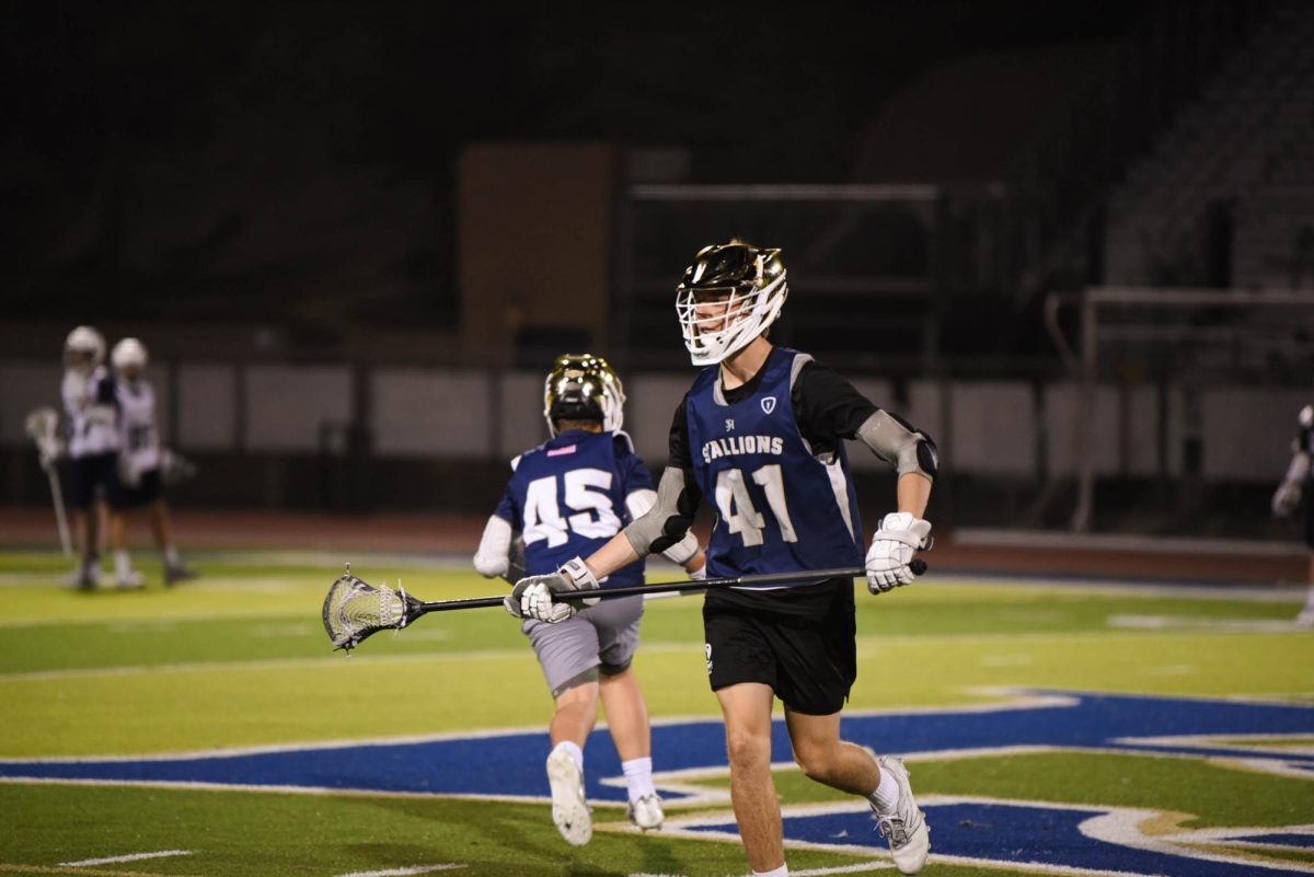 After sending the ball flying in a pass, a lacrosse player runs while practicing with excitement during the boys’ lacrosse tryouts. He and his fellow lacrosse players across different grades spent the night showing off their skills in hopes of making the team.
