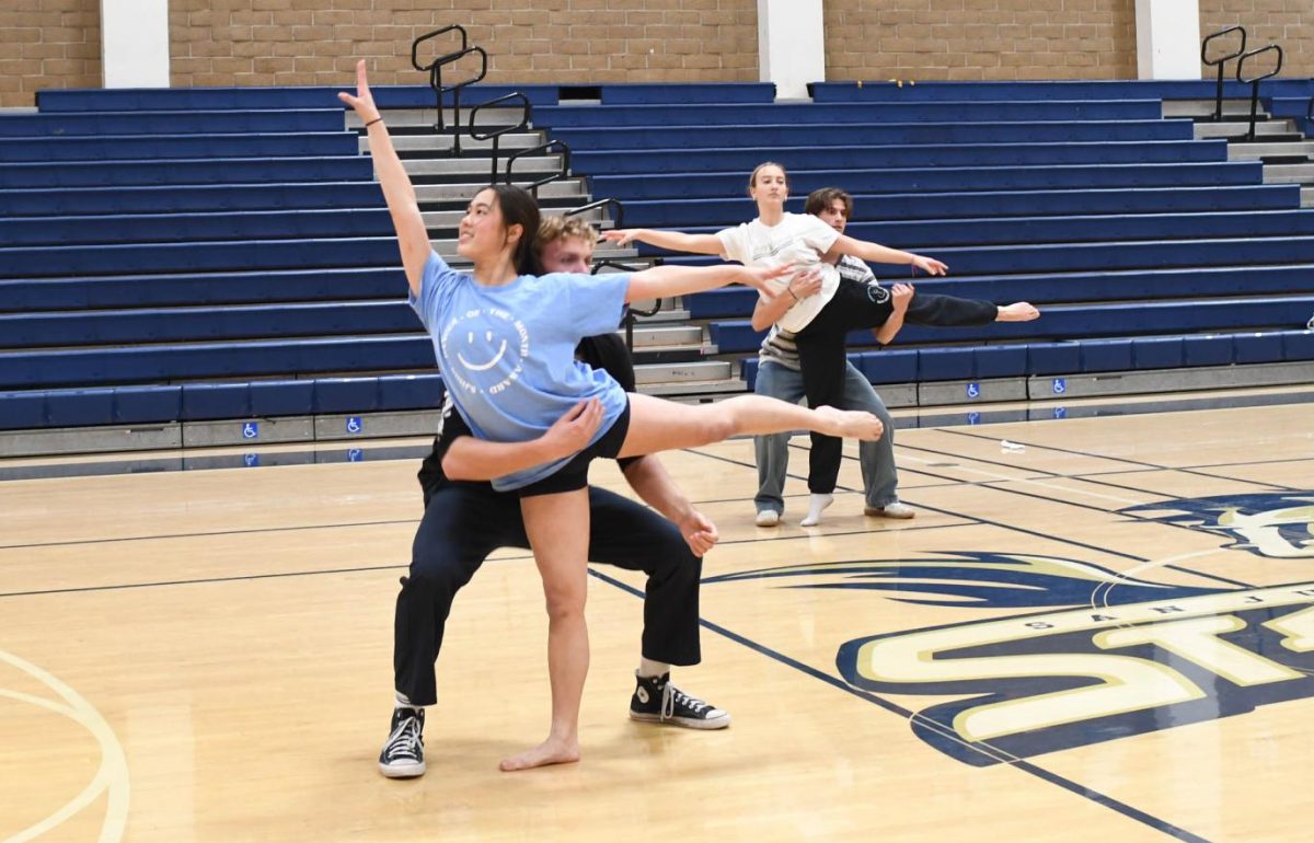 Rehearsing their pep rally routine, Amelia Mui (12) and Chase Walburger (12) practice a lift for the upcoming performance.