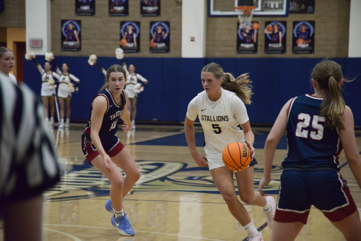 Dribbling past her opponents, Anna Shreeve (12) sprints towards the basket, to take a shot. The Stallions reigned victorious over the St. Margaret’s Tartans with a winning score of 41-37.