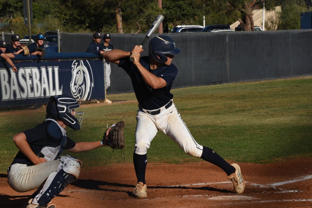 Preparing to swing, Nico Tasso (12) stays focused as the ball comes his way. Baseball players need helmets, cleats, bats, and mitts in order to be eligible to play the sport. Equipment costs can accumulate fast out of one’s paycheck, especially when players re-purchase broken or damaged gear.