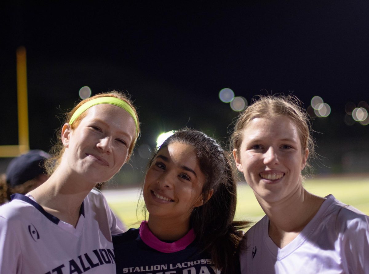 During the San Juan Hills Girls Lacrosse game, Captains Caitlyn Enright (12), Olivia Jarvis (12), and Sydney Beatty (12) stand together after the Stallions won against Newport Harbor 16-3.  Enright and Jarvis wear their bright green and pink headbands during every game, a tradition that has been passed down from the previous years before them.