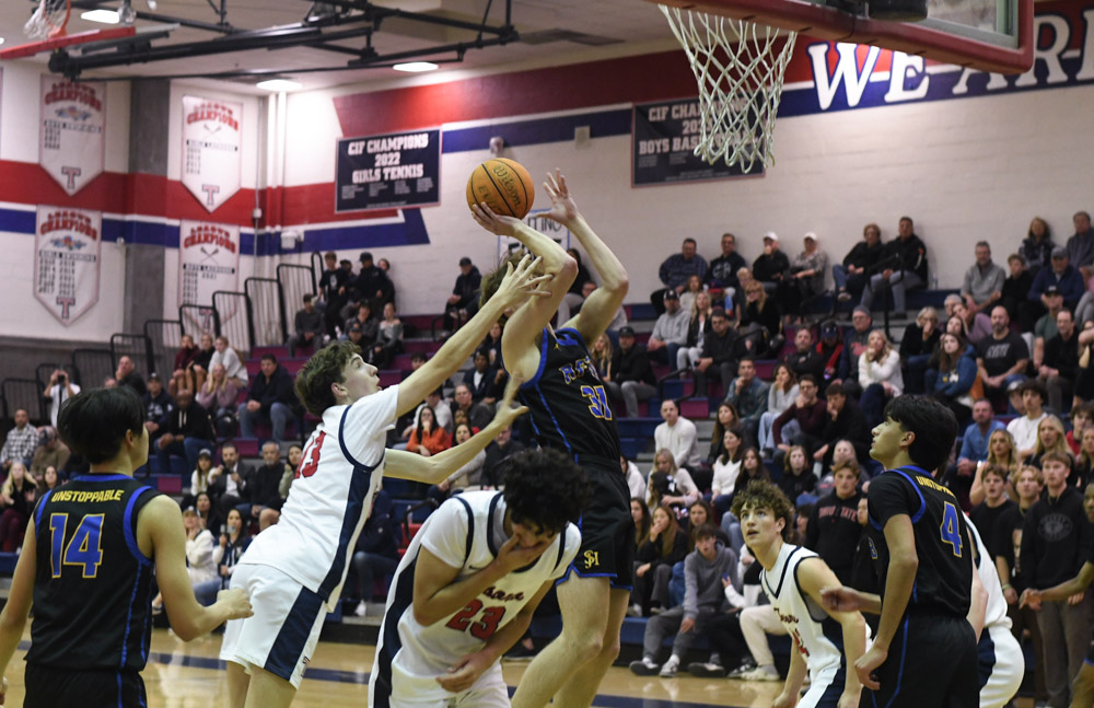  During the final minutes of the boys basketball game against Tesoro High School, Jake Strand (12) attempts to tie up a close score of 57-61. Blocked by the Tesoro defense, SJHHS offence continues to bypass the defense and to score.