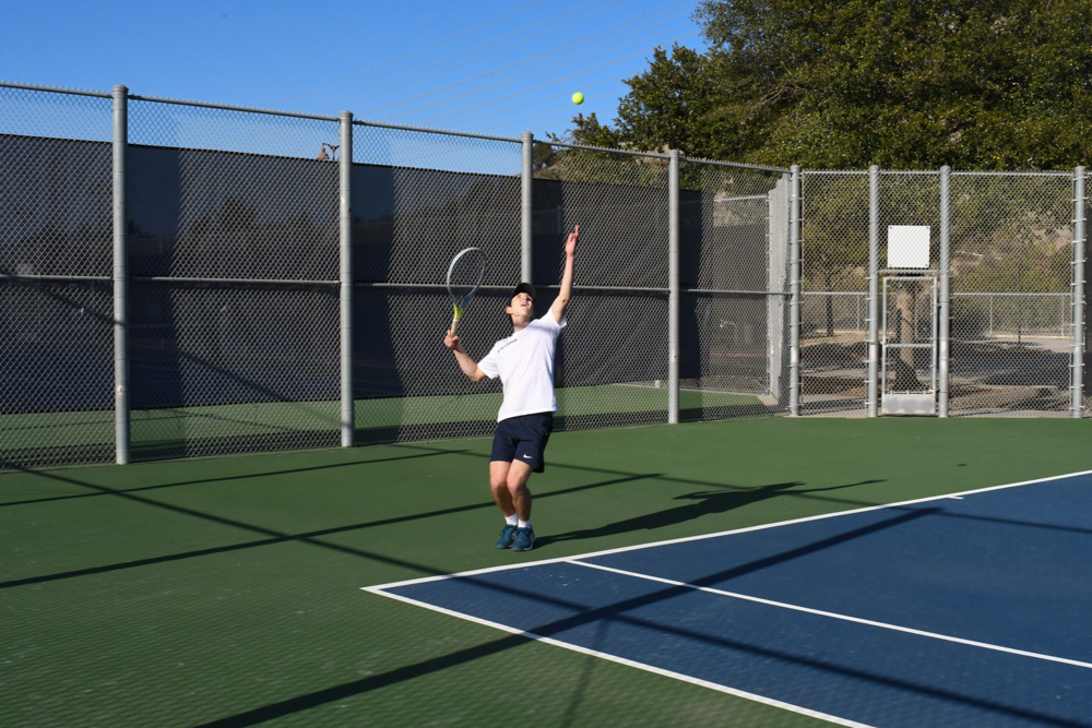 Tennis player Alex Mueller (11), serves a point in his doubles match set against Clovis HIgh School. 
