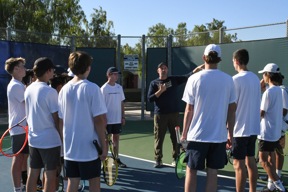 Boys SJHHS Varsity Tennis coach, Timothy Dileo, gives a pep talk to the boys team before their first match of the season against Clovis High School. 