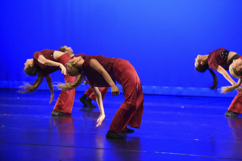 Dancers participate in advanced tricks in their high energy dance. Stallions, Sophia Loftus (11) and Peach Miller (11) are seen leading their group in flashy red costumes.