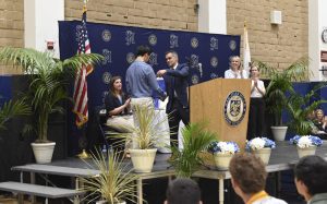 Graduating Seniors and their families come together for the San Juan Hills High School award ceremony, where lucky students get awarded for their academic and moral excellence. Principal, Cina Abedzadeh  awards Evan Lau for having the best grade point average in his senior class, Alexandra Easton, Trustees Lisa Zollinger and Gila Jones all clap and celebrate Lau’s success.  
