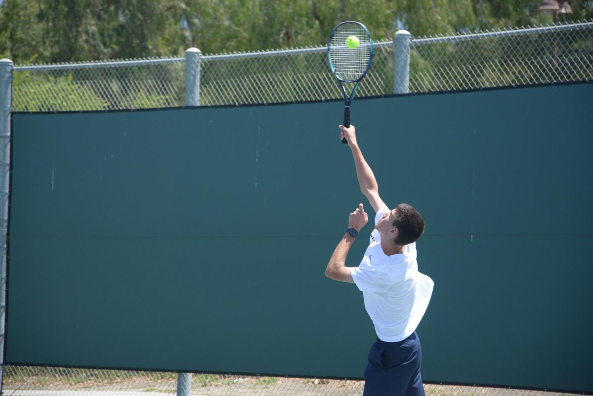 Fighting hard in a game of league finals, Jake Setele (12), playing with his doubles partner Alex Mueller (11), serves the ball with great enthusiasm. The Stallions fought hard against the Capo Valley Cougars as the third day of league finals raged on.