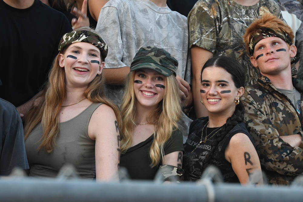 Students decorate themselves in camouflage as they support their team. Kelly Kilkenny, Lucy Garibaldi, Gabriella Bello, and Gaige Johnson (12) posed for a picture. 