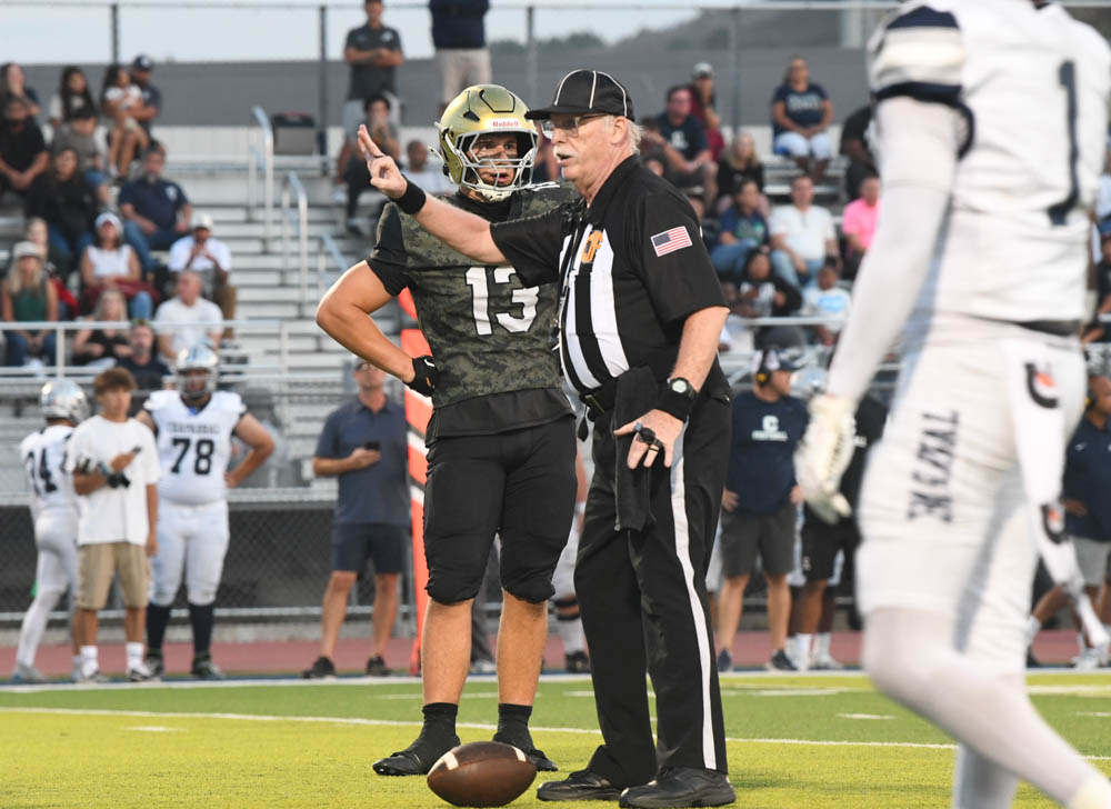 Referee’s surround the field and make sure the football game is being played fairly. A referee talks to football player Maxwell Porter (11).  