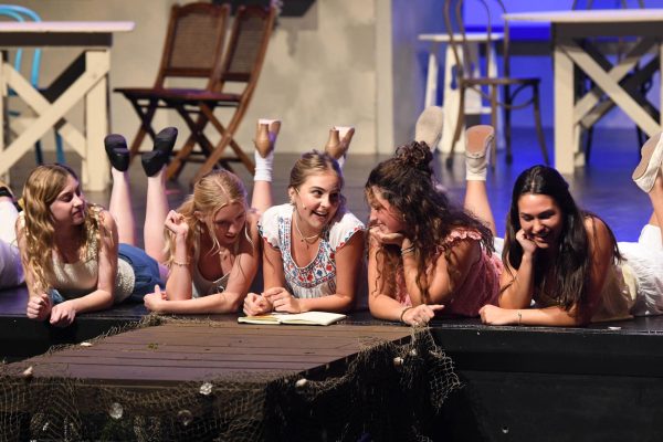 Mamma Mia is a theatrical musical about a young girl who invites three men from her mother’s past to her wedding as a way to figure out which one is her true father. Tali Doyle (10), who plays the leading role of Sophie Sheridan, laughs as she shows her friends and bridesmaids her mothers old diary.  