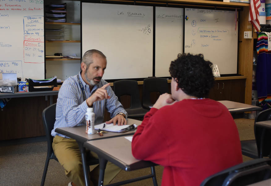 Across from Aiden Snavely (12), Spanish II and IV teacher Alvaro Serrano-Lopez works 1:1 with his students to help them prepare for their Seal of Bilteracy oral exam. The Seal of Bilteracy recognizes students who demonstrate proficient Spanish speaking skills, which embraces diversity and bilingualism across campus. 