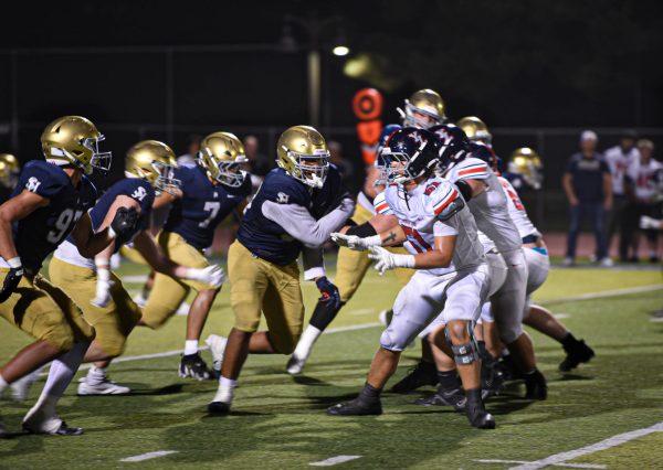 Determined to break through defence, the Stallions charge towards the opposing team. Landon Grant, Roman Paseka, Jonah Sanchez, Jacob Mullen, and Cooper Javorsky (12) all stand together and run towards their opponent.