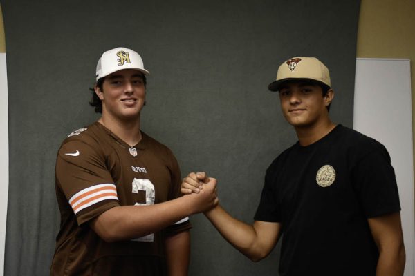 Cooper Javorsky (12) and Garrett Gondolfo (12) express their bonding upon success of recruitment. Gondolfo is going on to pitch at High Point University baseball while Javorsky has collected 17 offers for his position as an offensive linemen. 