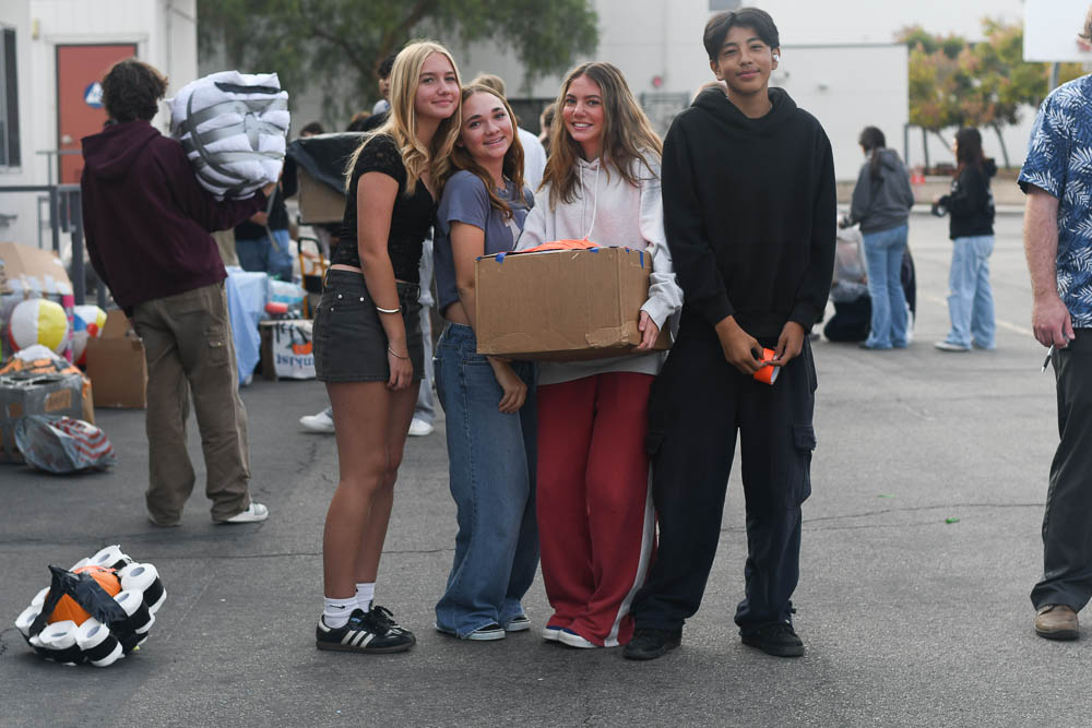  In first period physics, Zoey Vertin (10), Allie Felder (10), Naomi Christy (10), and Jacob Garcias (10), pose with their invention, while preparing to drop their pumpkin from H building balcony. With about a week to prepare, the four students strategize a cushioned fall for a pumpkin and are graded on the protection of the pumpkin.  