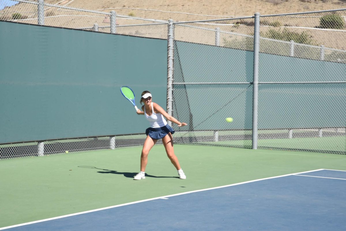  Tennis player Aubrey Meis (11), strikes a forehand during her league individuals match up against league opponent. Meis ultimately won the South Coast League Singles Champion title for the second year in a row.