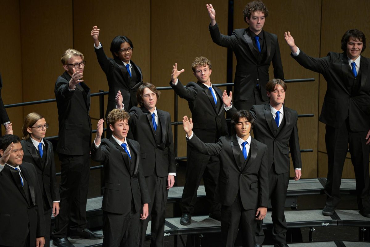 The men’s choir group sings while raising one of their arms in the air as part of their on-stage choreography. SJHHS highlights the fact that our school is one of the last schools to have an all men's choir group, by having them perform during the concert.