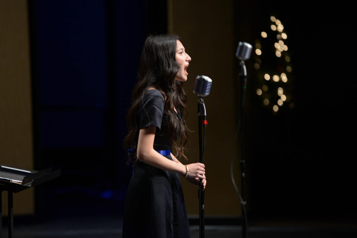Annabel Nguyen (11) looks out into the crowd as she sings the Christmas classic, O Holy Night. Her performance highlighted her vocal control and technique seen on stage.