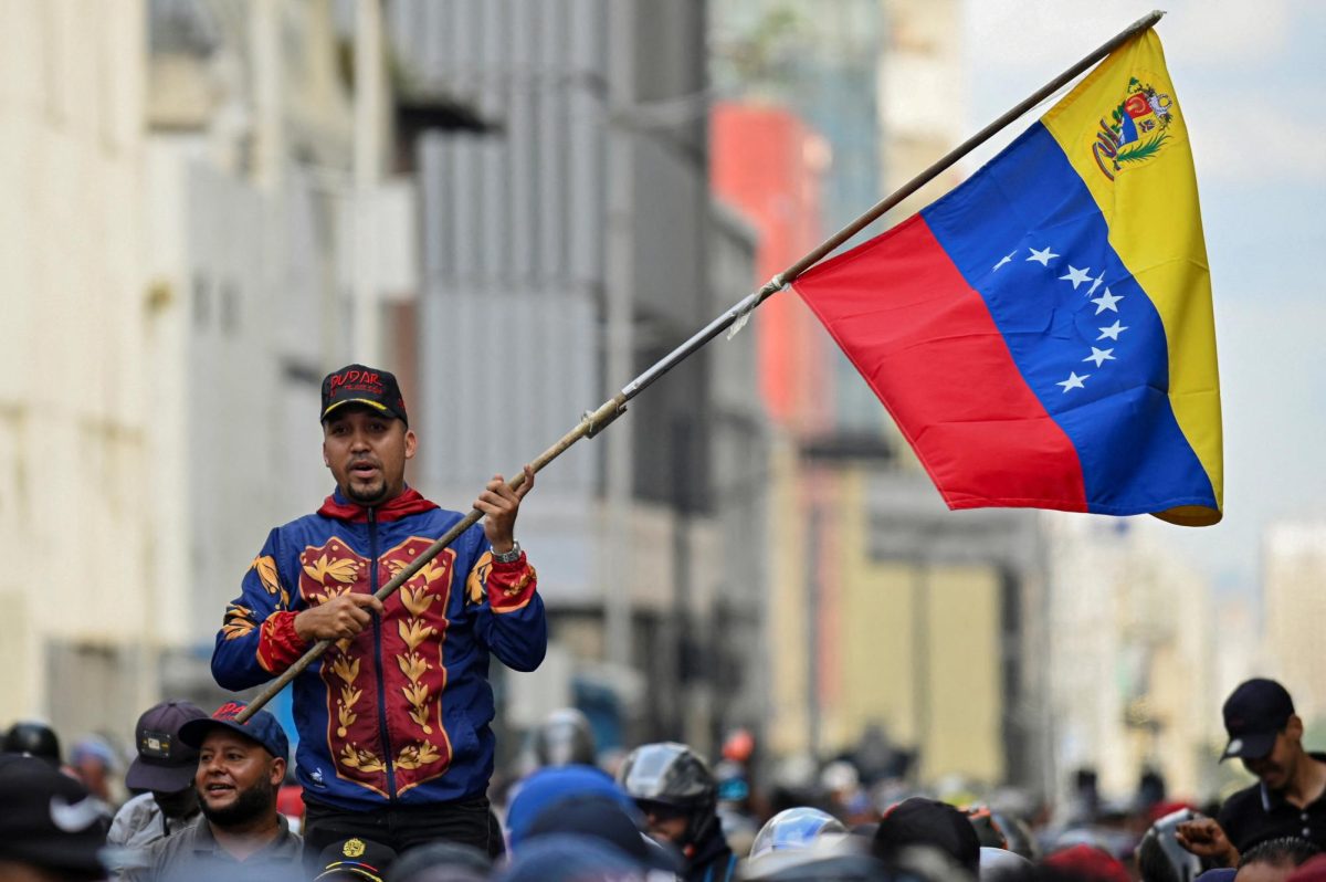 A demonstrator holds a Venezuelan flag during a march outside the National Assembly, on the day Vice President Delcy Rodriguez was formally sworn in as Venezuela's interim president, as U.S.-deposed President Nicolas Maduro appeared in a New York court after the Trump administration removed him from power, in Caracas, Venezuela January 5, 2026. REUTERS/Maxwell Briceno