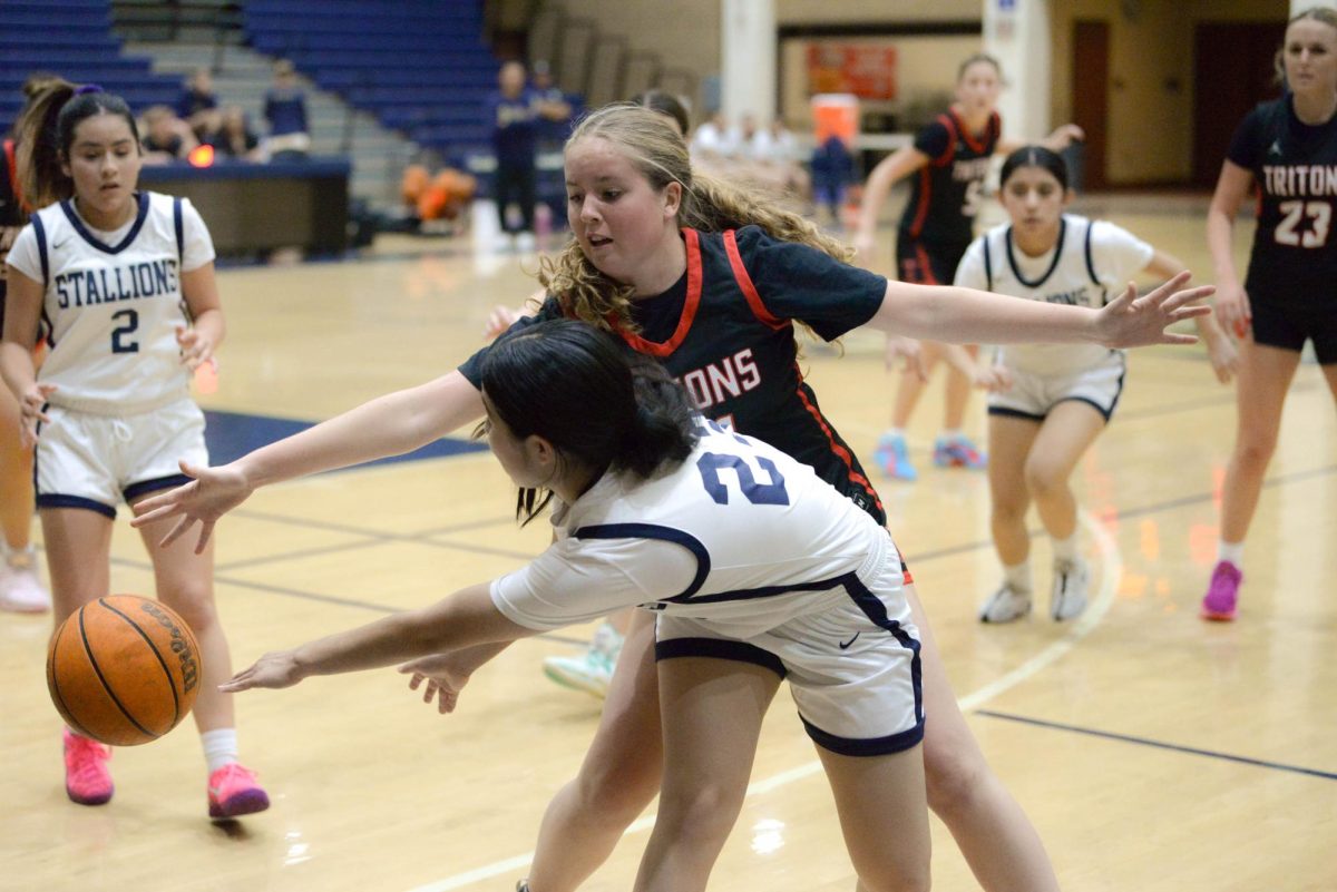 Katie Chavez (10) passes the ball to her teammate as the opposing team slowly closes in. Our JV girls basketball team competes against the San Clemente Tritons and sadly loses with the final score being 28-48.  
