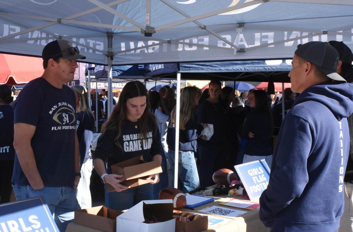 During Stallion Showcase, coach Brian Okumura and fellow athletes promote the girl’s flag football program. Stallion Showcase is an event that highlights various electives offered at San Juan Hills Highschool, along with information on school culture, campus, and athletics.