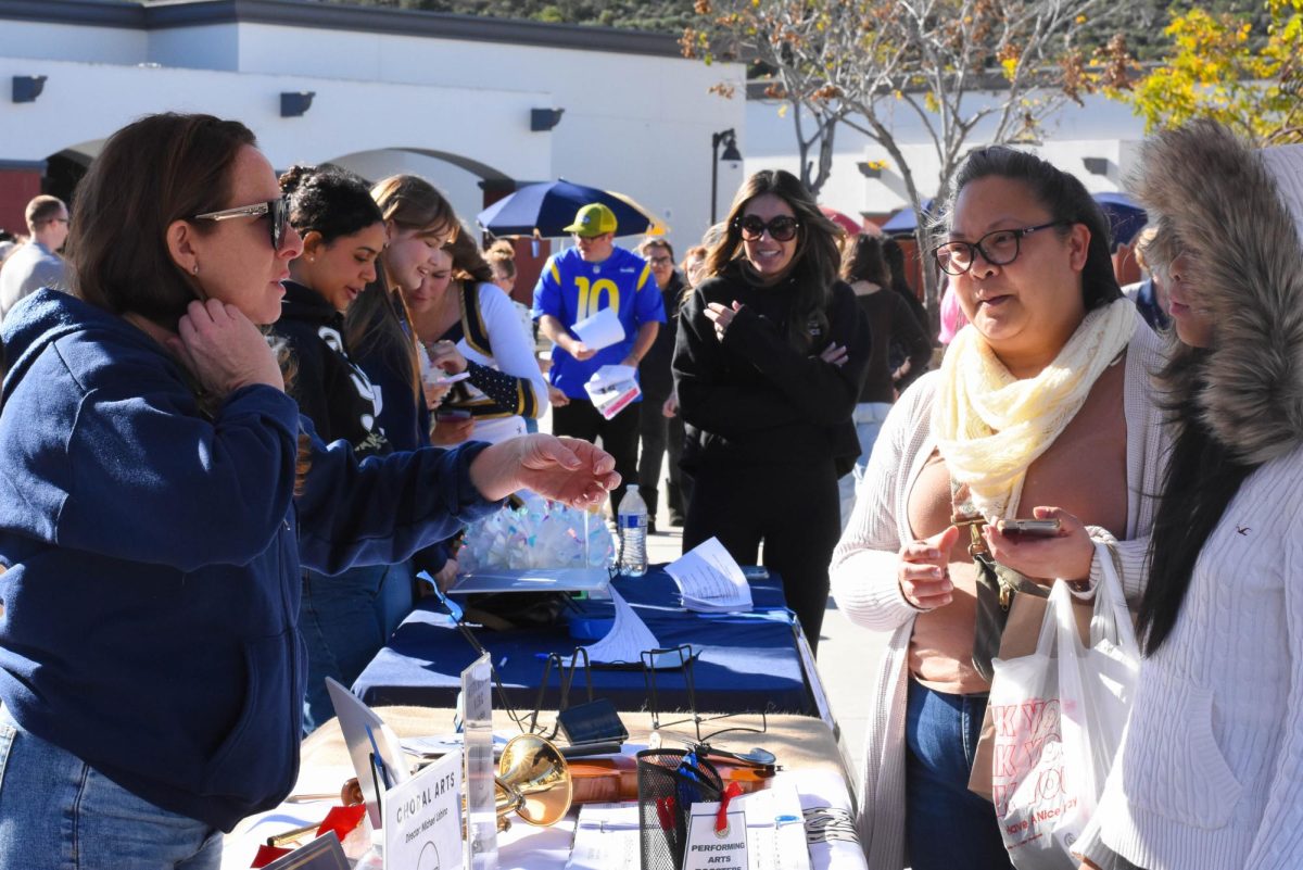  At the performing arts table during Stallion Showcase, parents and students converse with active members of San Juan Hills’ choir, theatre, dance, and more. They learn what each course has to offer, as well as how to join.