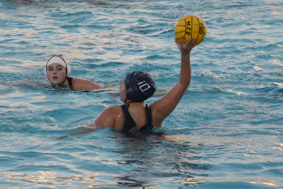 Senior girls waterpolo player, Gabby Valdez (12), gets ready to pass the ball to her fellow teammates, as they compete at home against Mission Viejo high school. 