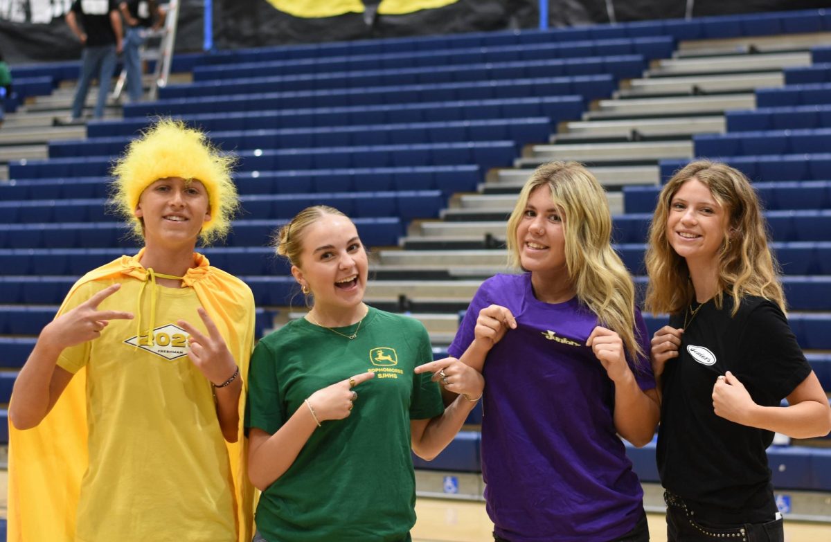 Members of SJHHS's ASB take a break from setting up the gym for the Clash of the Classes Pep Rally and smile for a photo. Each grade has a class color: Freshmen in yellow, Sophomores in green, Juniors in Purple, and Seniors in black. After an intense week of competitions between each grade, the class with the most school spirit will be announced at the end of the pep rally today.