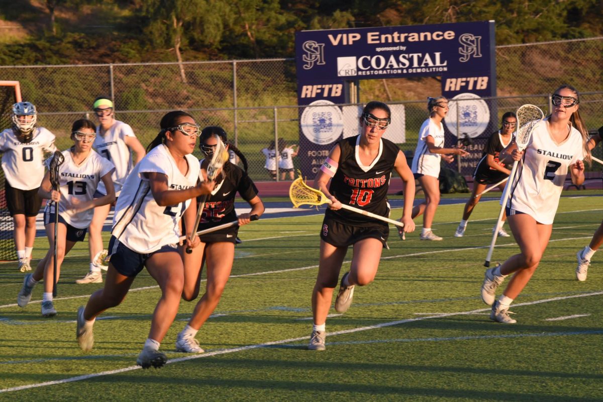 Junior player, Natalie Chen (11), runs with the ball in her stick as she's about to pass San Clemente defense players to score a point for her team. SJHHS ended the game with a victory of a score 7-3. 