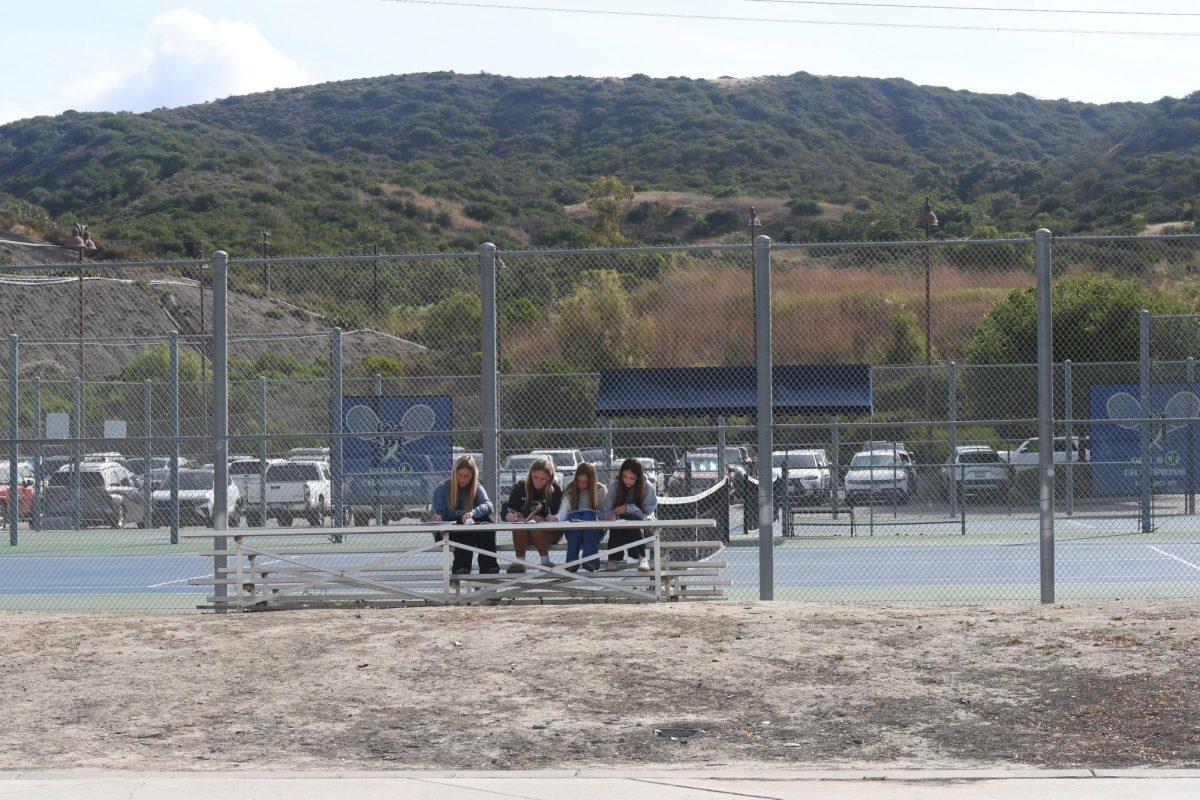 Señora Unzeta takes her class out to complete their work to enjoy the fresh air. Hudson Young (10), and her friends collaborate together on bleachers in front of the tennis courts, to complete worksheets that focus on deciphering which is appropriate in the sentence, por or para. 