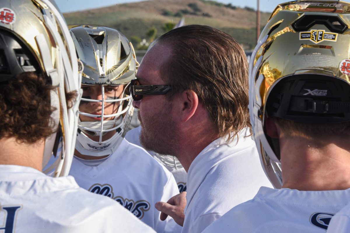 Coach Ben Poploskie shares advice with his team. Boys varsity lacrosse unfortunately loses against Aliso Niguel High School with the final score being 9-8. 