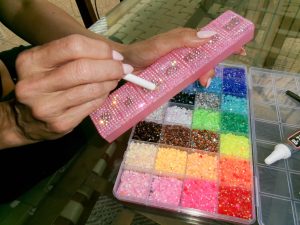 Once a trend associated with the early 2000s, bedazzling has slowly reemerged as both a fashion statement and creative outlet for the teens of today. From phone cases to pill boxes, people are finding ways to make ordinary objects feel more personal, playful, and expressive through tiny details and individual designs.