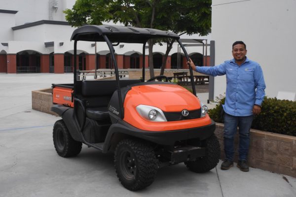 Standing beside his golf cart, Luis Ibarra is pictured with a bright smile on his face. Custodians actively work to ensure our school's campus is clean and working each day. 